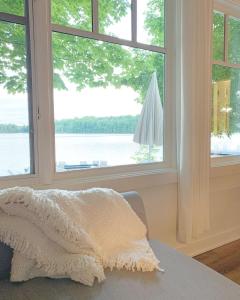 a bedroom with a window with a view of the water at Beachside on Lake Muskoka in Port Carling