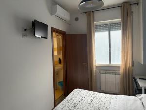 a bedroom with a bed and a television and a window at B&B D'Amare in San Salvo