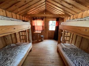a room with two bunk beds in a cabin at Ülesaare kämping in Kelnase