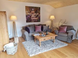 a living room with a couch and a coffee table at CHIEMSEE MOUNTAIN LODGE - adults only - Eleganz auf 95qm - Traumblick - XL-Balkon - Privatsphäre in Bernau am Chiemsee