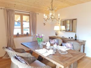 a dining room with a wooden table and chairs at CHIEMSEE MOUNTAIN LODGE - adults only - Eleganz auf 95qm - Traumblick - XL-Balkon - Privatsphäre in Bernau am Chiemsee