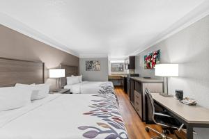 a hotel room with two beds and a desk at Red Roof Inn Ardmore in Ardmore