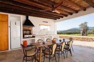 a kitchen and dining room with a table and chairs at Villa Na Ribes in Sant Carles de Peralta