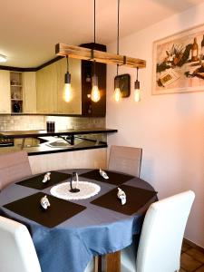a dining room table with chairs and a kitchen at Apartments Unterer Kochbuck in Crailsheim