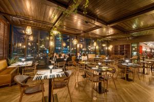 Ein Restaurant mit Tischen und Stühlen und Menschen im Hintergrund in der Unterkunft Hotel Nodo - El primer hotel de negocios en Chile in Santiago
