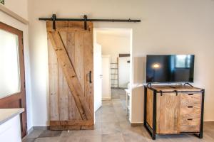 a sliding barn door in a room with a television at Casa do Alto in Vilamoura