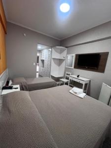 a hotel room with two beds and a flat screen tv at Ancona Center Hotel in Amparo