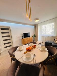 a living room with a table and chairs and a couch at ApartamentySnu, Apartament Nad Potokiem in Radom