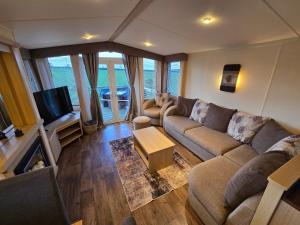 a living room with a couch and a tv at Paddock view in Pembrokeshire