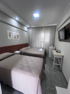 a hotel room with two beds and a television at Ancona Center Hotel in Amparo +16 photos