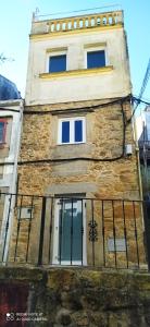 a stone building with windows and a fence at Casa Roda 39 in A Guarda