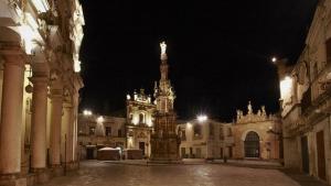 a statue in the middle of a street at night at Casa Nachiro - 16th Century Oil Mill Historic Dimora in Nardò