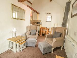 a living room with two chairs and a table at Mews Cottage 7 in Keswick