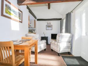 a living room with a table and chairs at Mews Cottage 6 in Keswick