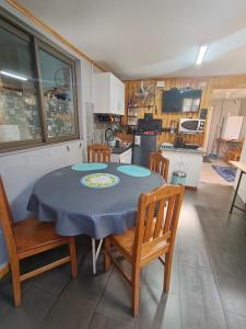 a kitchen with a table and two chairs and a table and a kitchen at EL ROBLE 2 CHILLaN in Chillán +19 photos