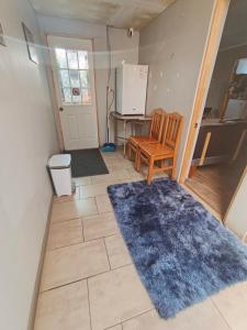 a kitchen with a refrigerator and a chair and a rug at EL ROBLE 2 CHILLaN in Chillán