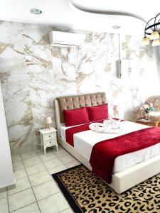 a bedroom with a large bed with red pillows at Sweet Home Suite in Korinthos