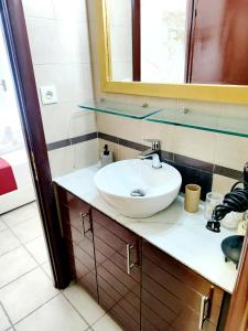 a bathroom with a sink and a mirror at Sweet Home Suite in Korinthos