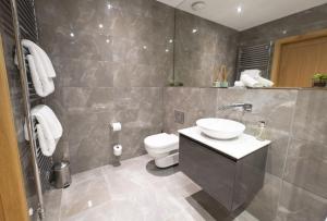 a bathroom with a sink and a toilet at Royal Gardens Apartment 10 in Dornoch +15 photos
