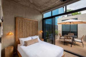 a bedroom with a bed and a patio with a table at The Sandhaus - Boutique Design Villa with 8 Suites in Jacó +133 photos