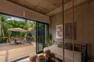a bedroom with a swinging bed and a patio at The Sandhaus - Boutique Design Villa with 8 Suites in Jacó
