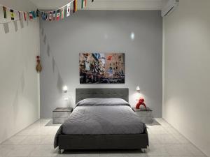 a bedroom with a bed and a painting on the wall at Vesuvian Tales in San Giorgio a Cremano