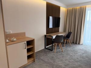 a hotel room with a desk and two chairs at Baltic Waves Ex LAZUR in Gąski