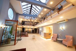 a lobby with chairs and a clock on the wall at 4 Epoxes Hotel Spa in Kato Loutraki