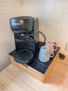 a coffee maker on a wooden stand with a mug at Haus Haiderbach Nähe A3 in Wittgert