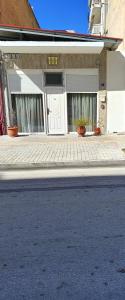 a white house with two doors on a street at Sweet Home Suite in Korinthos +3 photos