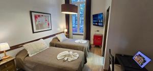 a hotel room with two beds and a television at Hotel del Sol in La Plata