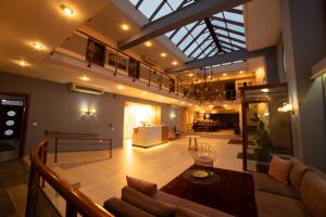 a living room with a couch and a glass ceiling at 4 Epoxes Hotel Spa in Kato Loutraki
