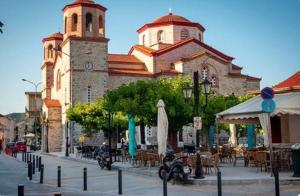 a large building with a clock tower on a street at Petrino Minimal in Dhéndra