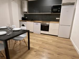 a kitchen with a black table and white appliances at Apartamento en Eibar in Éibar +6 photos
