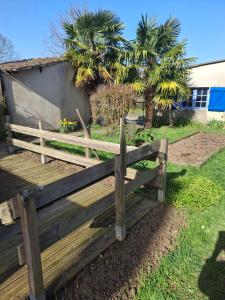 a wooden bench sitting in the grass near a building at Chambre dans village tranquille in Saint-Laurent-de-la-Plaine