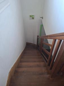 a staircase in a room with white walls and wooden floors at Chambre dans village tranquille in Saint-Laurent-de-la-Plaine
