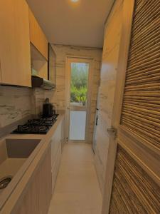 a small kitchen with a stove and a hallway at Laguna Beach Ecohotel in Tolú