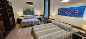 a bedroom with two beds and a couch and a painting at Hotel del Sol in La Plata