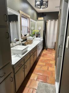 a bathroom with two sinks and two mirrors at Around the Bend Bungalow in Fredericksburg