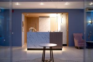 a lobby with a counter and a table and a chair at 4 Epoxes Hotel Spa in Kato Loutraki