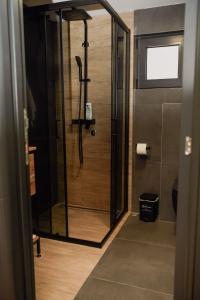 a shower with a glass door in a bathroom at A frame CHILL House in Brasina