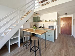 a kitchen with a table and some stairs at Duplex T2 - Madonna di a Sarra in Calvi
