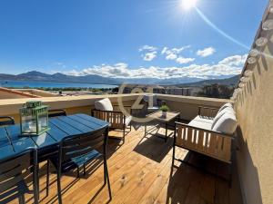 a balcony with tables and chairs and a view of the ocean at Duplex T2 - Madonna di a Sarra in Calvi
