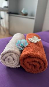 two towels with flowers on top of a bed at Sleep&Coffee&Go in Trier