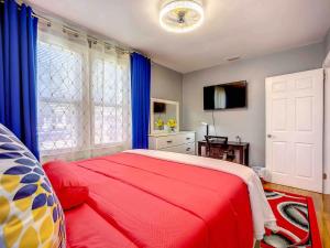 a bedroom with a red bed and blue curtains at Private 2BR 10 Min to Airport & Downtown in Jacksonville