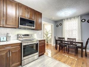 a kitchen with wooden cabinets and a table with chairs at Private 2BR 10 Min to Airport & Downtown in Jacksonville