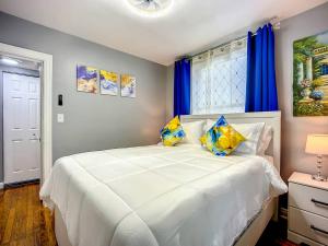 a bedroom with a large white bed with blue curtains at Private 2BR 10 Min to Airport & Downtown in Jacksonville