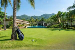 a bag leaning against a palm tree next to a house at Wisdom Park Caravan Camp Pattaya in Ban Khao Mai Kaeo