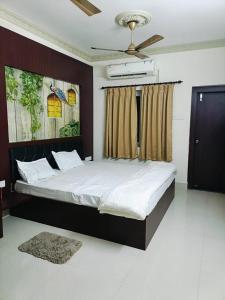 a bedroom with a large bed with a ceiling fan at MAHAMAYA CONVENTION and HOTEL in Mālatīpātpur