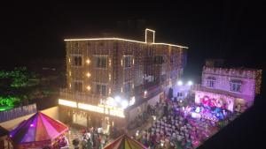 a crowd of people standing in front of a building at night at MAHAMAYA CONVENTION and HOTEL in Mālatīpātpur +19 photos